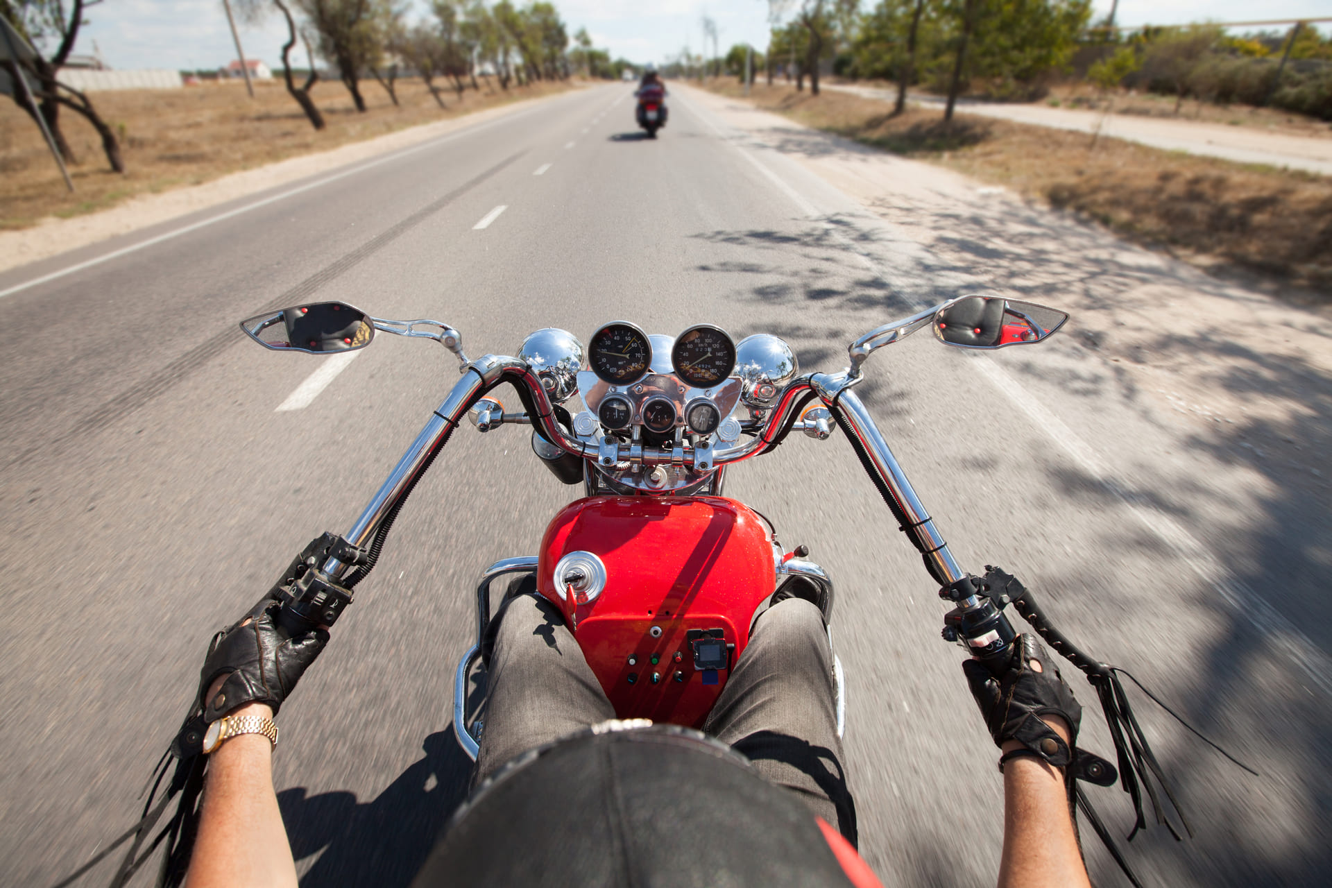 Point-of-view shot from a rider on a red cruiser motorcycle on an open road